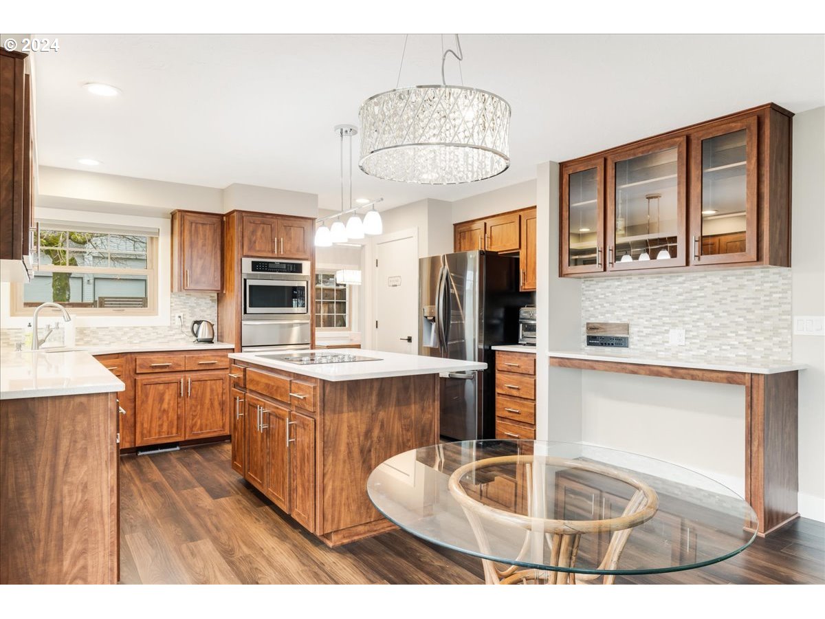 1812 Southwest Nancy Drive Gresham, OR 97080 - Photo 16 of 39 a kitchen with stainless steel appliances granite countertop a sink dishwasher and a fireplace with wooden floor