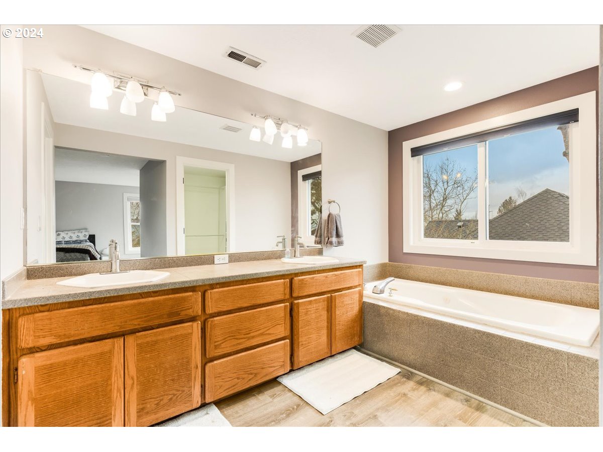 1812 Southwest Nancy Drive Gresham, OR 97080 - Photo 25 of 39 a bathroom with a tub a sink and a large mirror