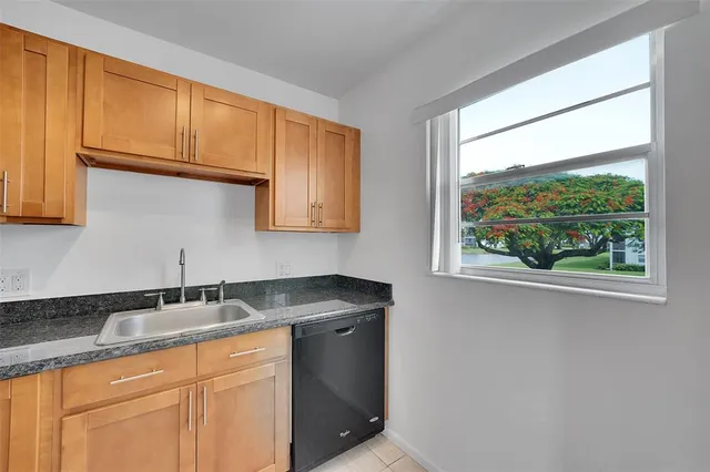 a kitchen with granite countertop a sink and a window