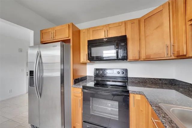 a kitchen with stainless steel appliances granite countertop a refrigerator microwave and stove top oven