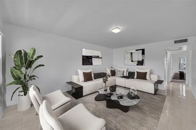 a living room with furniture potted plant and white walls