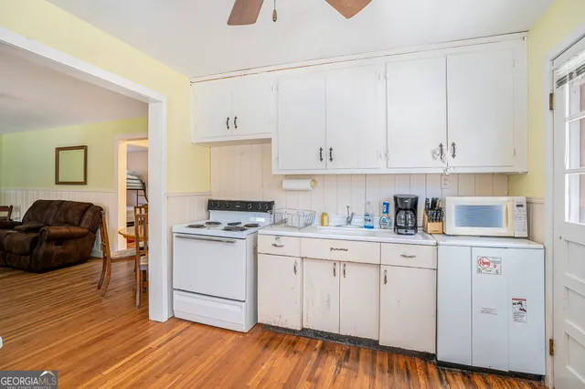 a kitchen with stainless steel appliances granite countertop a stove a sink and white cabinets