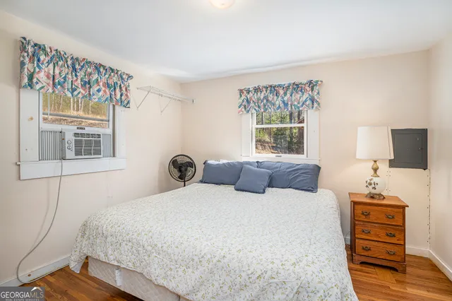 a bedroom with a bed and a flat tv screen on the dresser