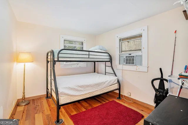 a bedroom with a bed and a dresser next to a window