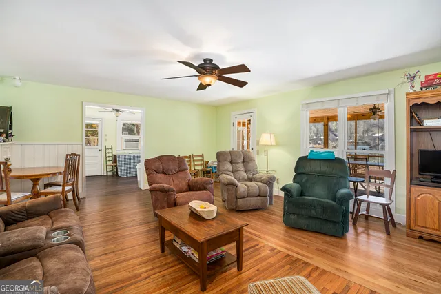 a living room with furniture a flat screen tv and wooden floor
