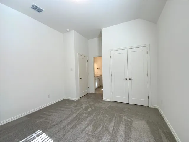 a large kitchen with stainless steel appliances granite countertop a stove a sink a refrigerator and white cabinets with wooden floor