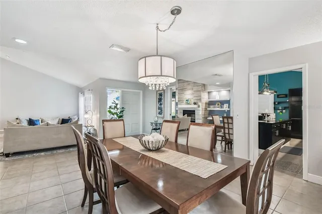 a living room with furniture a chandelier and a fireplace