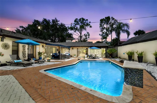 a view of a house with swimming pool and sitting area