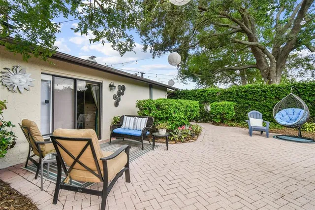 a view of a patio with table and chairs potted plants and a palm tree