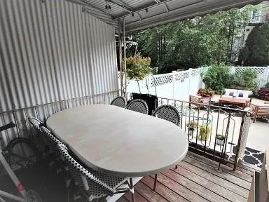 a view of a patio with table and chairs with wooden floor and fence