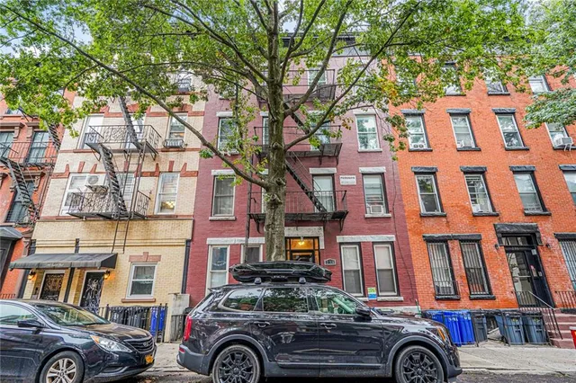 a front view of a residential apartment building with a yard