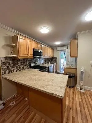 a kitchen with a refrigerator a stove a sink dishwasher and wooden cabinets with wooden floor