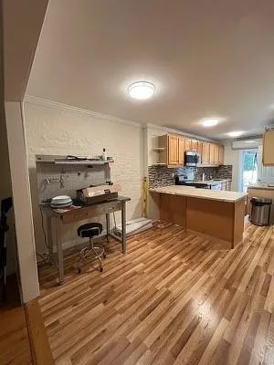 a kitchen with stainless steel appliances kitchen island granite countertop a table chairs in it and wooden floors