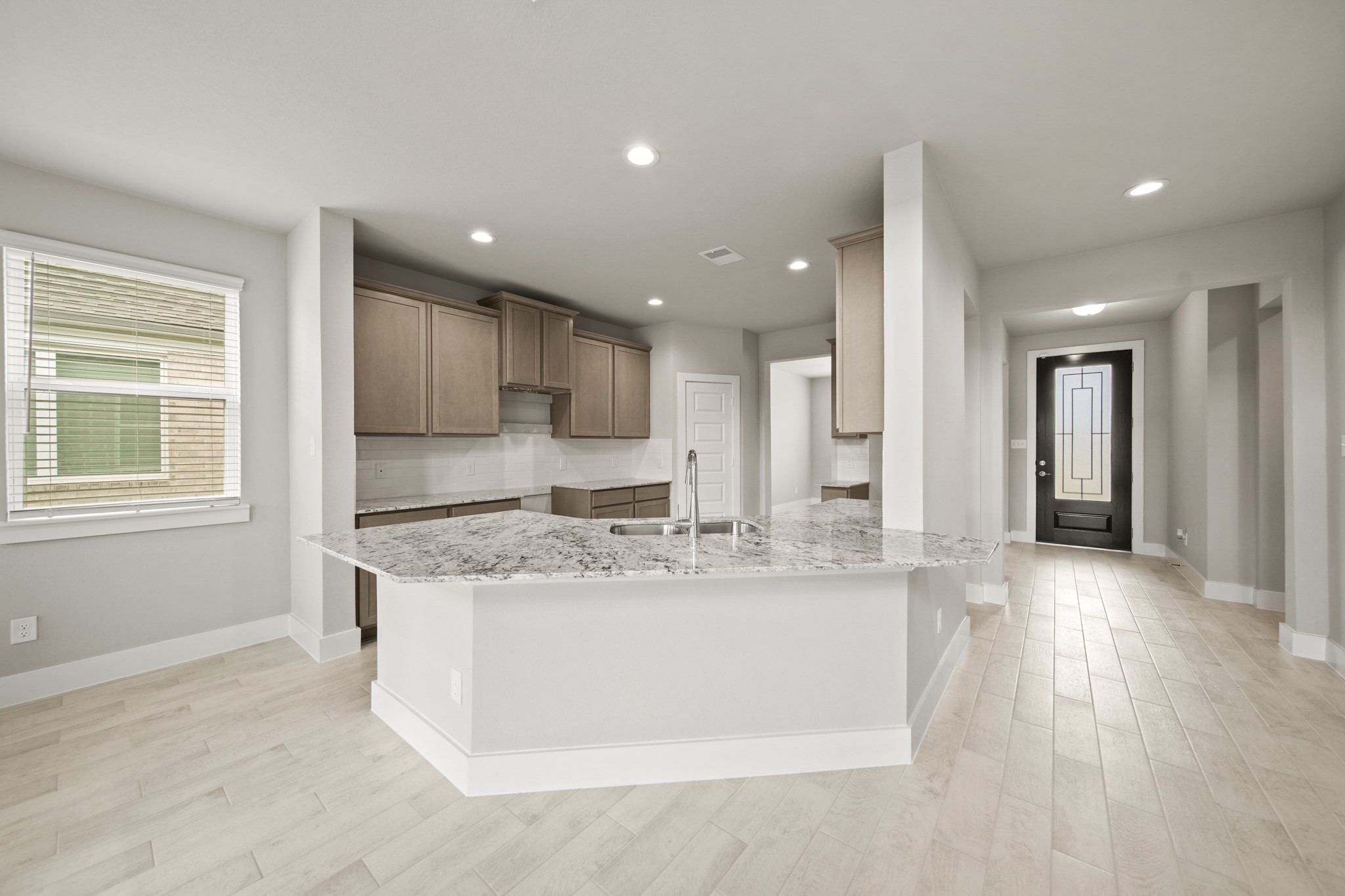 18227 Windy Knl Way Houston, TX 77084 - Photo 3 of 37 a large kitchen with stainless steel appliances granite countertop a stove a sink a refrigerator and white cabinets with wooden floor