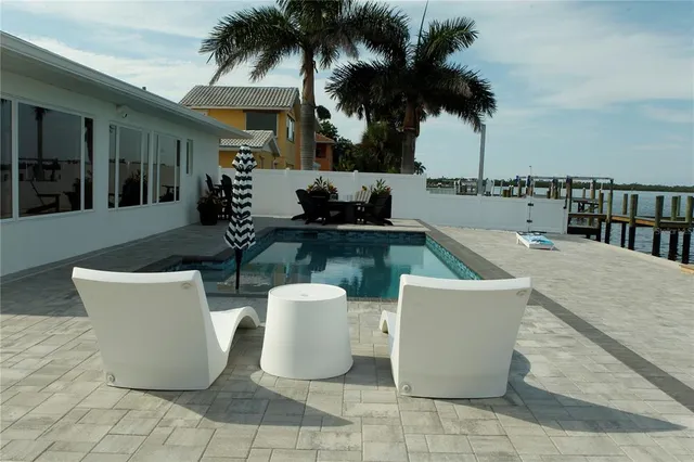 a view of a patio with table and chairs potted plants and palm trees
