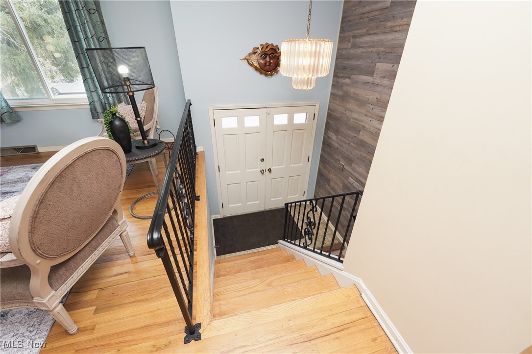 2674 Smith Road Fairlawn, OH 44333 - Photo 24 of 31 Entrance foyer featuring baseboards, wood finished floors, stairs, and a notable chandelier