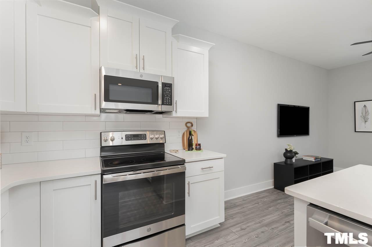 4 South Laird Drive, Unit 7 Clayton, NC 27520 - Photo 12 of 26 a kitchen with cabinets stainless steel appliances and wooden floor