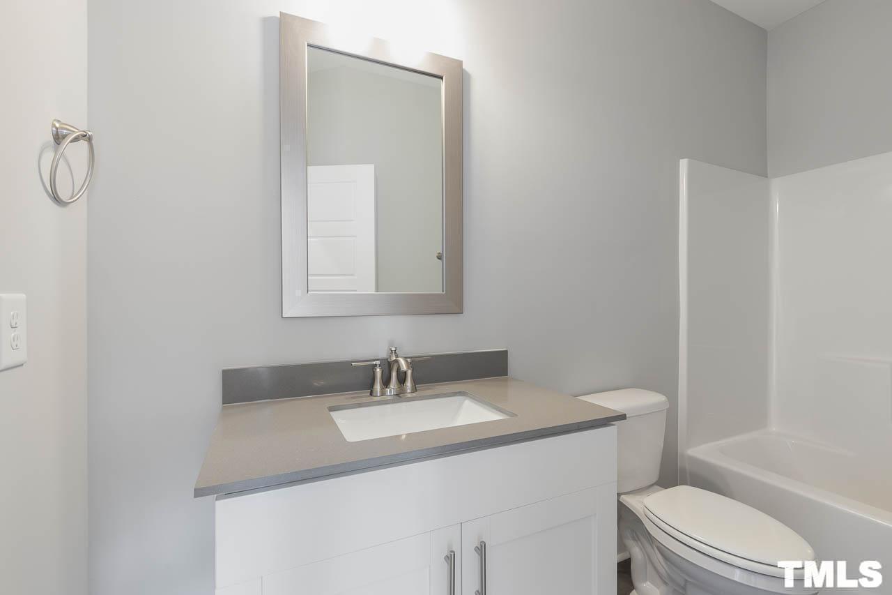 4 South Laird Drive, Unit 7 Clayton, NC 27520 - Photo 19 of 26 a bathroom with a sink toilet and a mirror