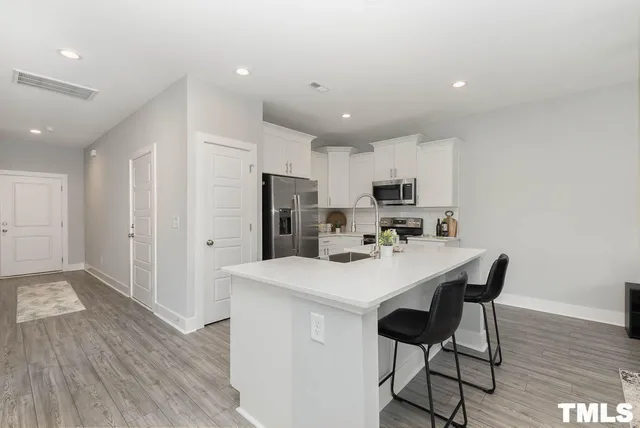 a kitchen with stainless steel appliances a refrigerator and a stove top oven