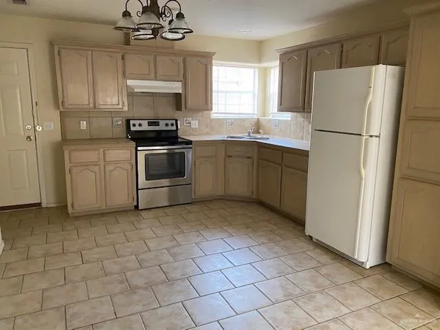 a kitchen with a refrigerator a stove a microwave and cabinets
