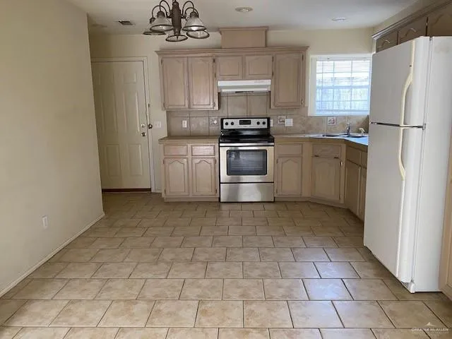 a kitchen with a refrigerator sink and cabinets