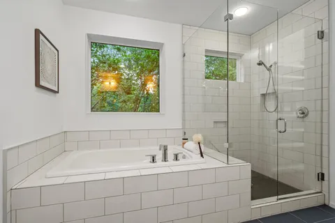 a white bath tub sitting next to a shower