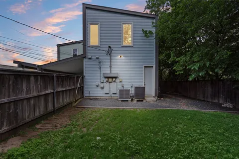 a view of backyard with wooden fence and large trees