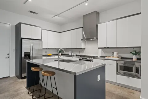 a kitchen with stainless steel appliances a sink stove and refrigerator