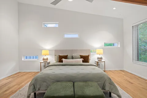 a bedroom with a bed and wooden floor
