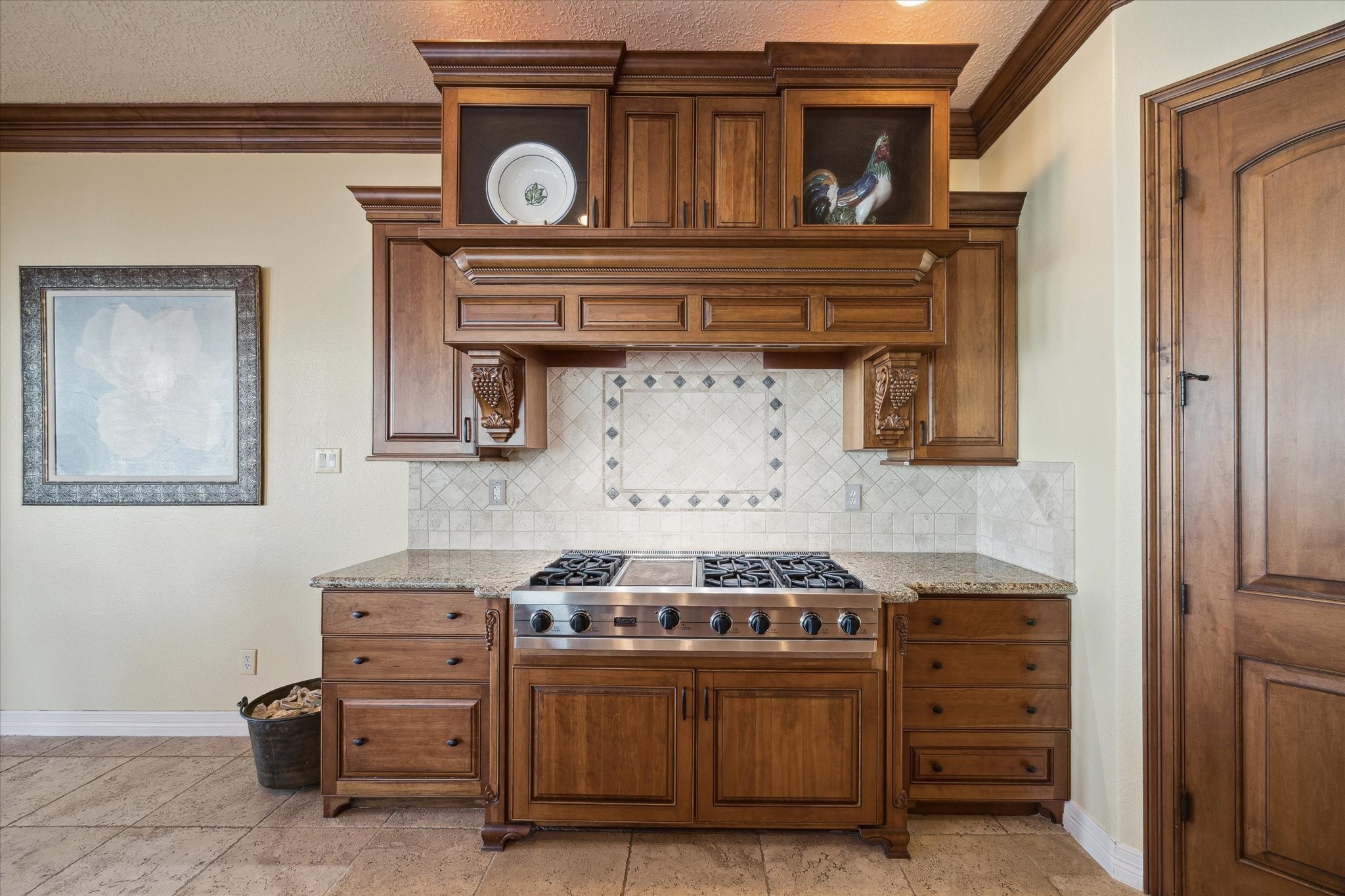 1406 Todville Road Seabrook, TX 77586 - Photo 25 of 49 A VIKING 6 BURNER GAS RANGE WITH GRIDDLE IS FRAMED BY A CUSTOM RANGE HOOD, CORBELS AND GLASS FRONT CABINETS.