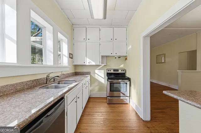 a kitchen with granite countertop a sink and a stove top oven
