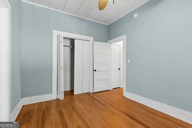 a view of empty room with wooden floor