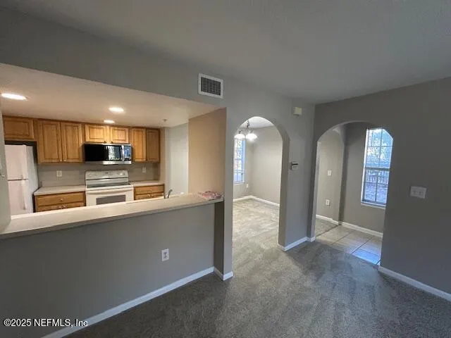 a large kitchen with stainless steel appliances granite countertop a large counter top and a stove