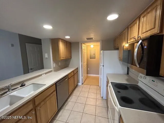 a kitchen with stainless steel appliances a sink a stove a refrigerator a sink and cabinets