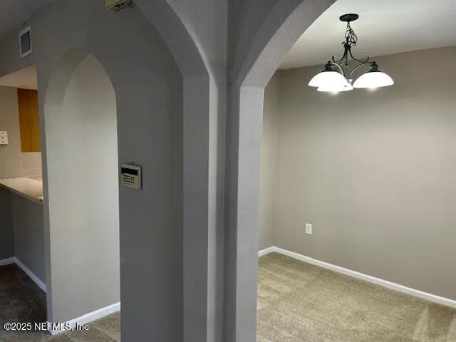 a view of a hallway with chandelier