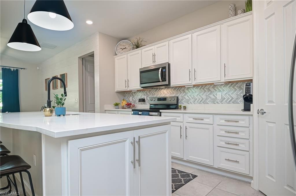 2137 Clementine Street Naples, FL 34120 - Photo 11 of 32 a kitchen with white cabinets and sink