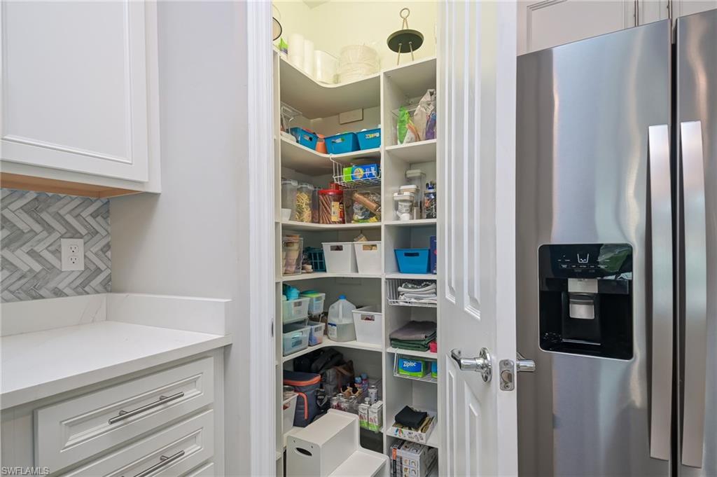 2137 Clementine Street Naples, FL 34120 - Photo 12 of 32 a room with a refrigerator and cabinets