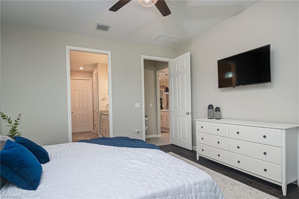 2137 Clementine Street Naples, FL 34120 - Photo 15 of 32 a bedroom with a bed and a flat screen tv
