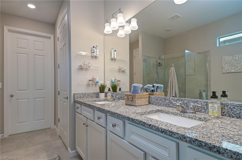2137 Clementine Street Naples, FL 34120 - Photo 16 of 32 a bathroom with a granite countertop sink and a mirror