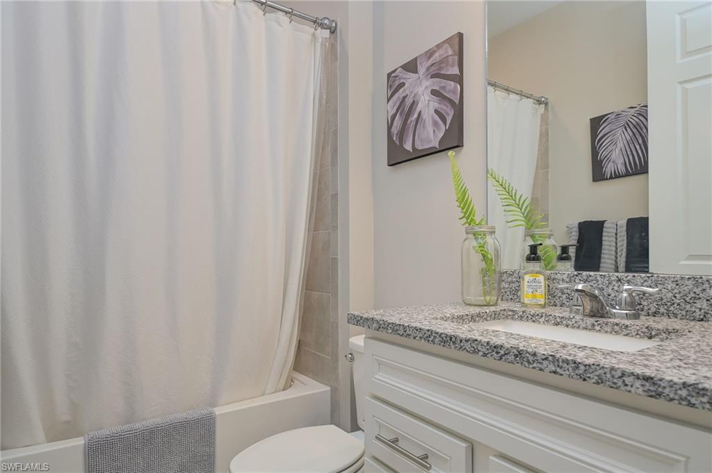 2137 Clementine Street Naples, FL 34120 - Photo 21 of 32 a bathroom with a granite countertop sink and a toilet