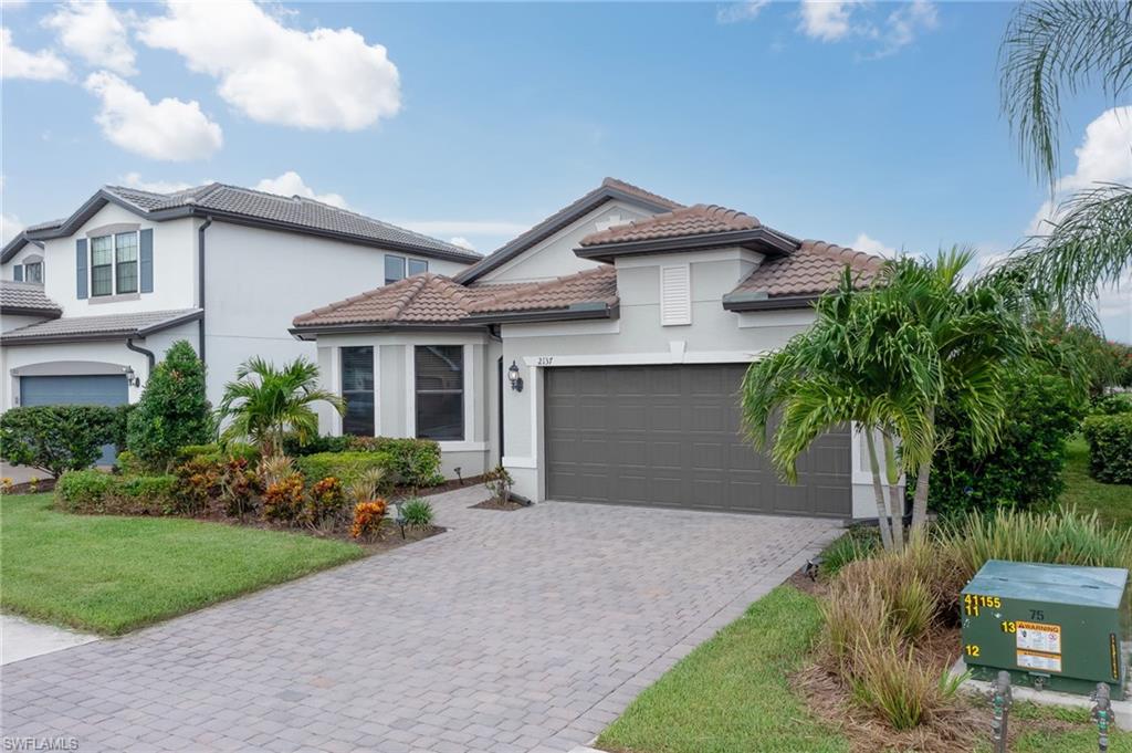 2137 Clementine Street Naples, FL 34120 - Photo 27 of 32 a front view of a house with a garden and plants