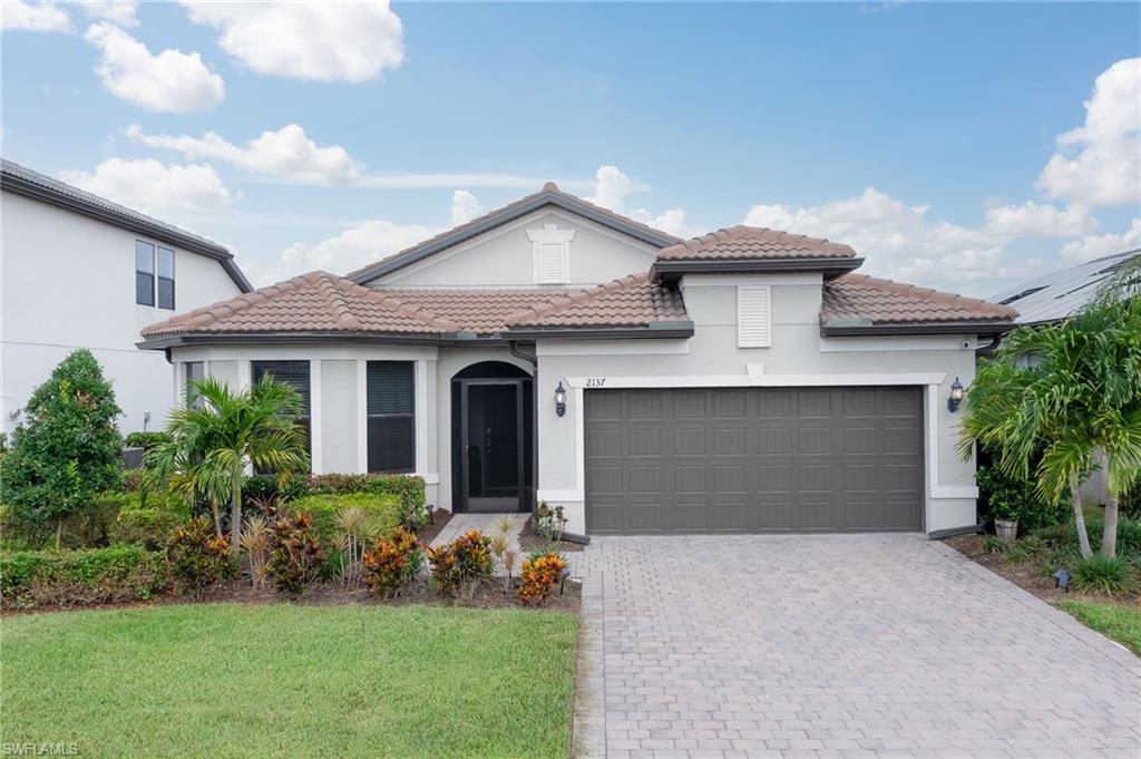 2137 Clementine Street Naples, FL 34120 - Photo 28 of 32 a front view of a house with a yard and garage