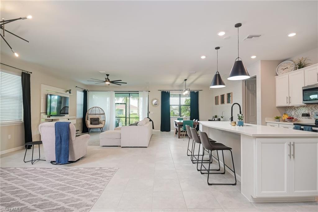 2137 Clementine Street Naples, FL 34120 - Photo 3 of 32 a living room with furniture a large window and kitchen view