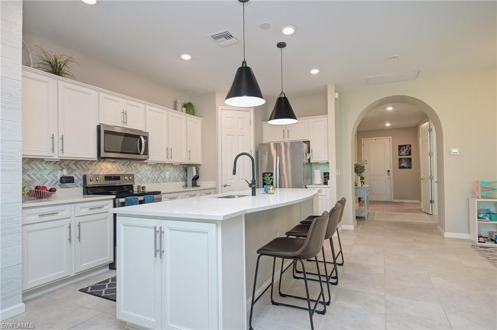 2137 Clementine Street Naples, FL 34120 - Photo 9 of 32 a kitchen with a sink stainless steel appliances and cabinets