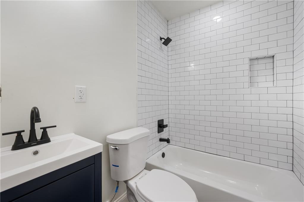 405 4th Street Northeast, Unit 24 Atlanta, GA 30308 - Photo 10 of 19 a bathroom with a toilet a sink a mirror and bathtub