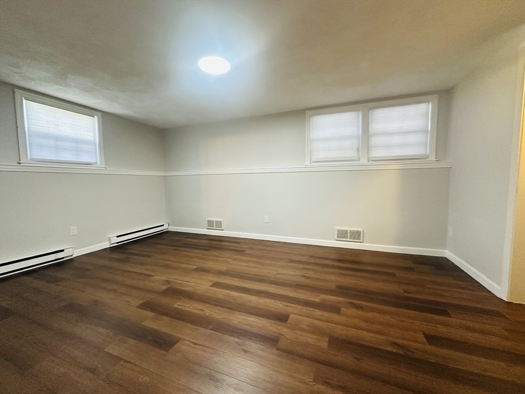 222 School Street, Unit 4 Walpole, MA 02081 - Photo 13 of 16 an empty room with wooden floor and windows