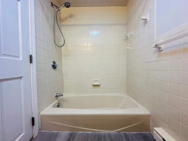 a bathroom with a bath tub with a shower