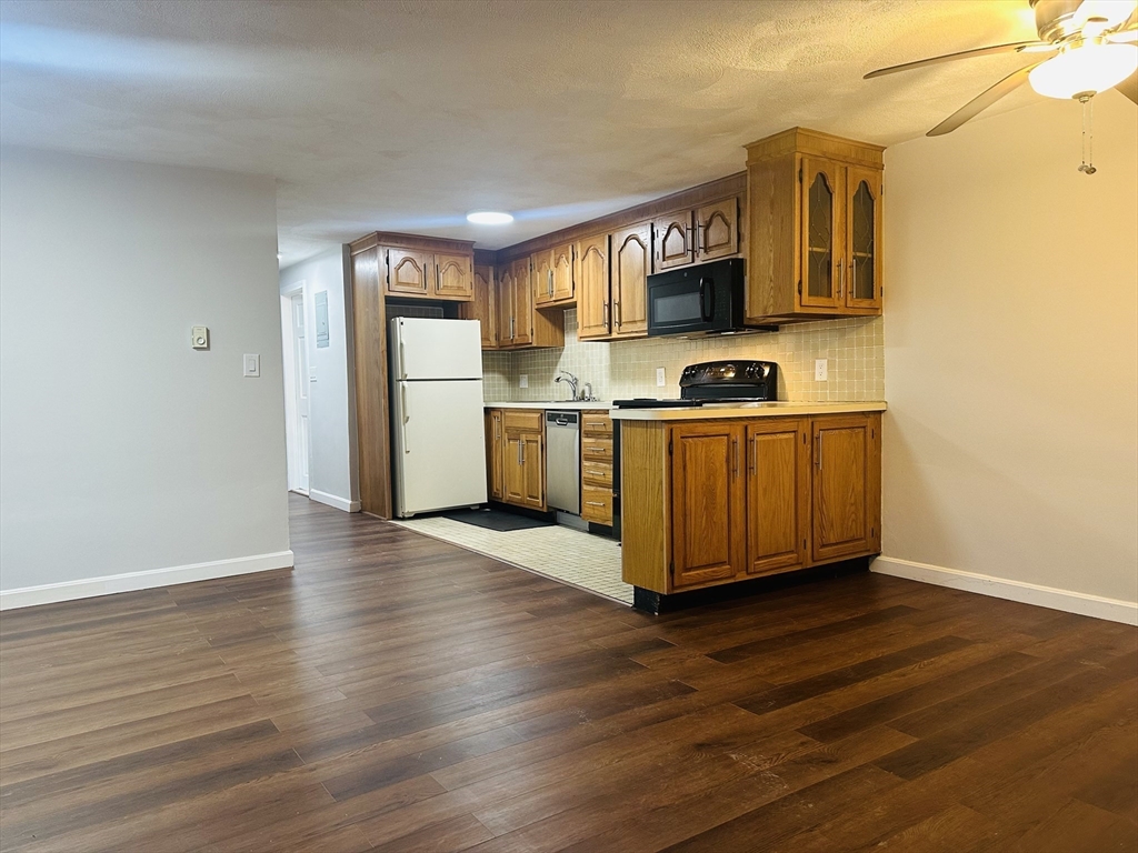 222 School Street, Unit 4 Walpole, MA 02081 - Photo 2 of 16 a kitchen with stainless steel appliances granite countertop a stove top oven a sink dishwasher and a refrigerator with wooden floor