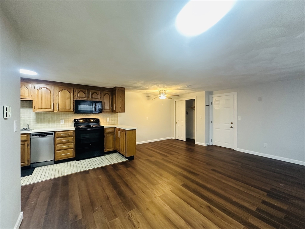 222 School Street, Unit 4 Walpole, MA 02081 - Photo 4 of 16 a kitchen with stainless steel appliances granite countertop a stove and a refrigerator