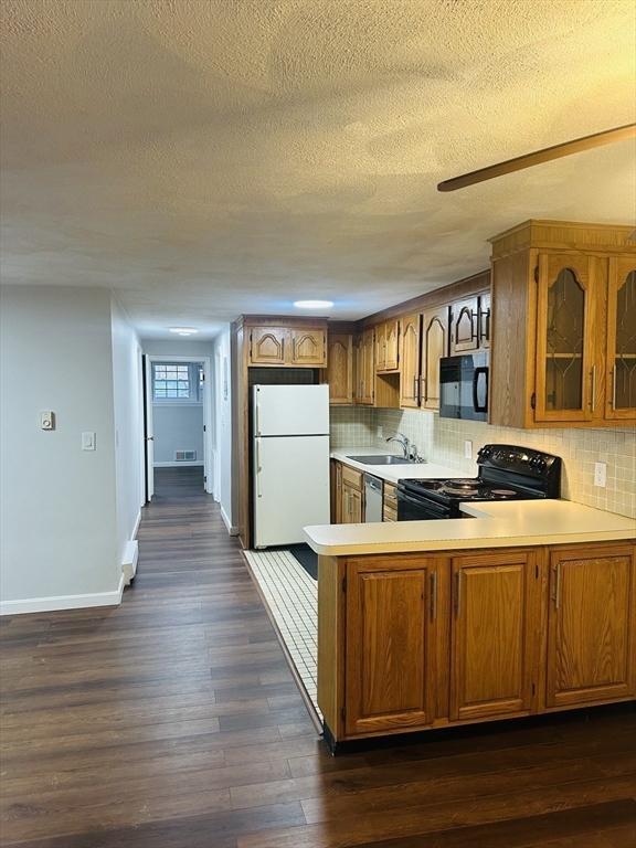 222 School Street, Unit 4 Walpole, MA 02081 - Photo 5 of 16 a kitchen with stainless steel appliances granite countertop a sink and wooden floor